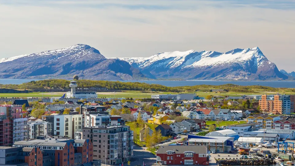 Bodø by med snøkledde fjell i bakgrunnen.