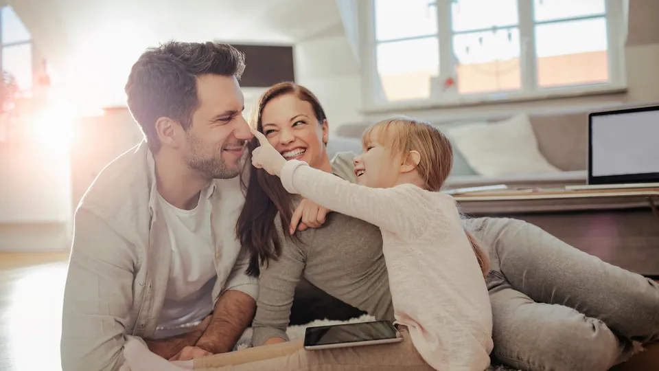 Familie leger sammen på gulvet derhjemme.