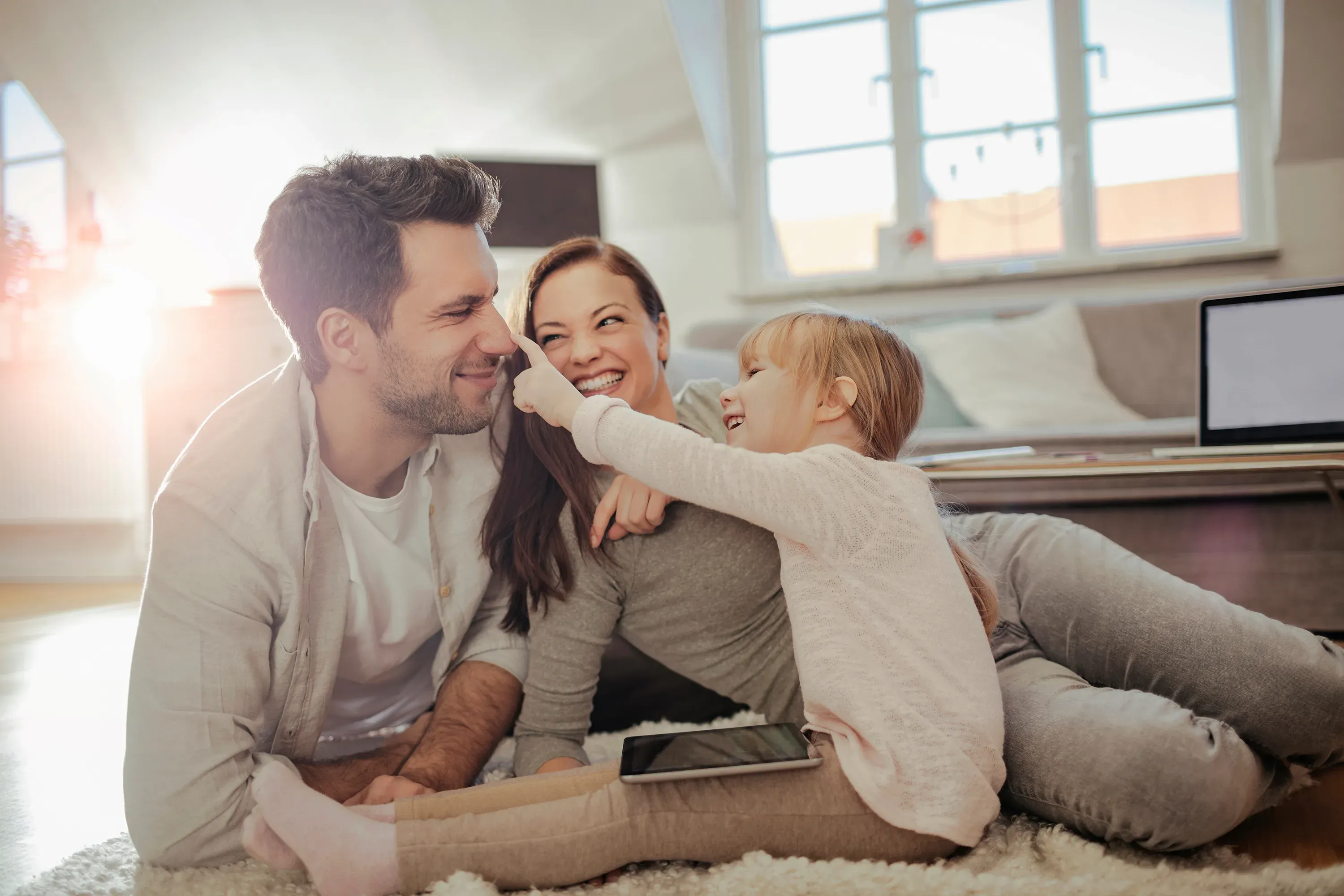 Famiglia felice gioca sul pavimento di casa.