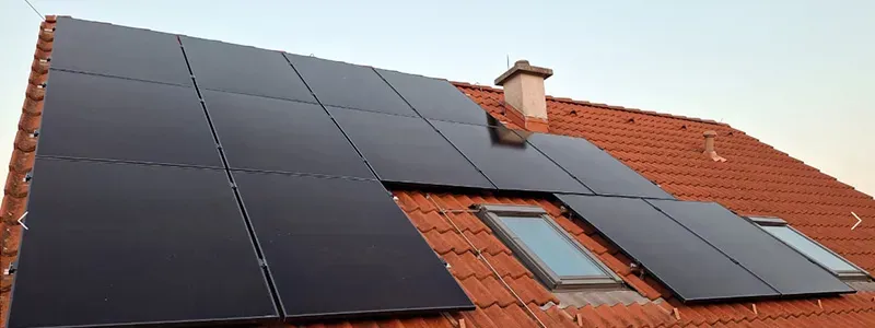 Voltea GmbH – Photovoltaikanlage auf rotem Ziegeldach mit Dachfenstern und Schornstein
