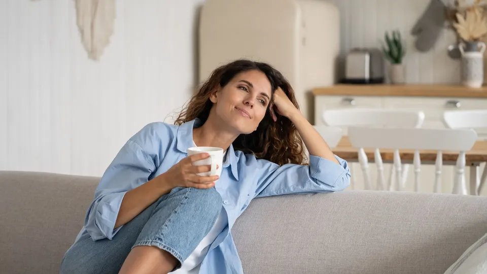 Kvinde slapper af hjemme med en kaffe.