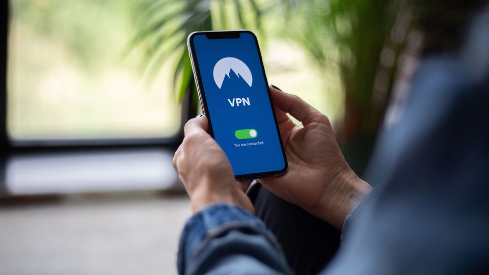 Bilde av en person som holder en mobil i hånda hvor VPN er skrudd på.