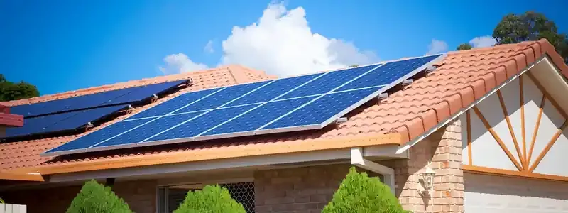 Pannelli solari installati sul tetto in tegole di una casa in mattoni sotto un cielo azzurro.